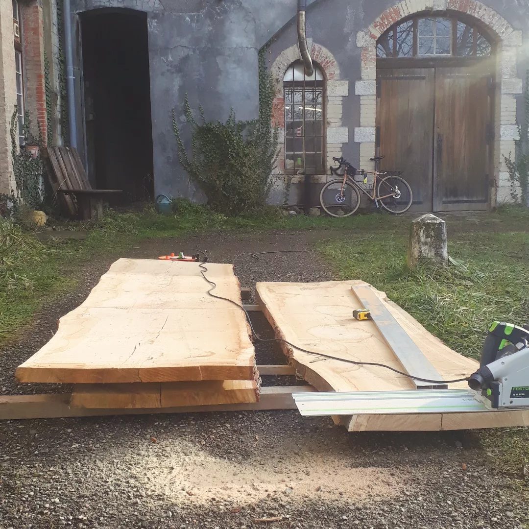 Planches de bois massif préparées devant l'atelier